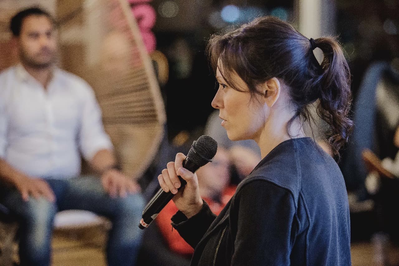 Inés hablando con micrófono durante una experiencia corporativa